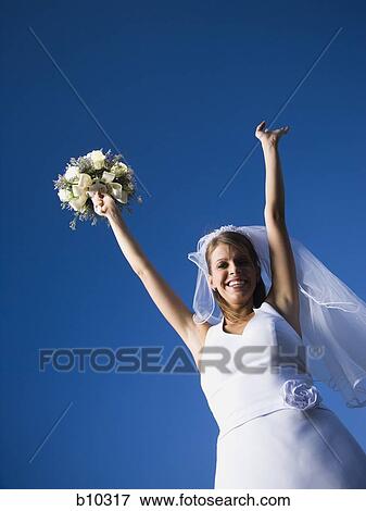 Portrait of a bride holding a bouquet of flowers with her arms raised View Large Photo Image Stock Photo - Portrait of a bride holding a bouquet of flowers with her arms raised. Fotosearch