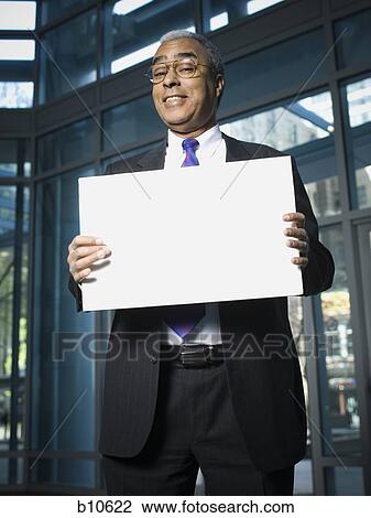 Portrait of a businessman holding a blank sign View Large Photo Image Stock Image - Portrait of a businessman holding a blank sign. Fotosearch