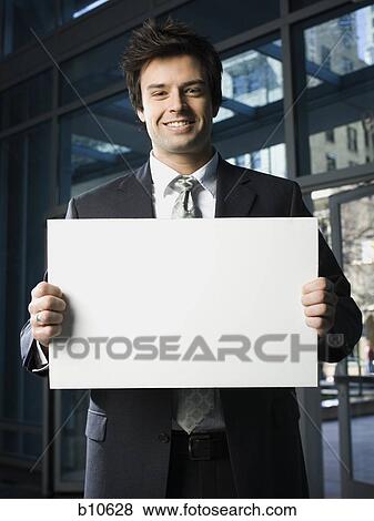 Portrait of a businessman holding a blank sign View Large Photo Image Stock Photo - Portrait of a businessman holding a blank sign. Fotosearch