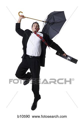 Portrait of a businessman holding an umbrella and jumping View Large Photo Image Stock Image - Portrait of a businessman holding an umbrella and jumping. Fotosearch