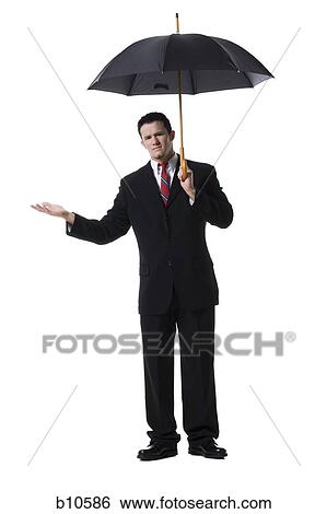 Portrait of a businessman holding an umbrella View Large Photo Image Stock Photograph - Portrait of a businessman holding an umbrella. Fotosearch