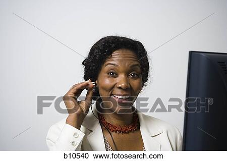 Portrait of a businesswoman wearing a headset and smiling View Large Photo Image Stock Image - Portrait of a businesswoman wearing a headset and smiling. Fotosearch