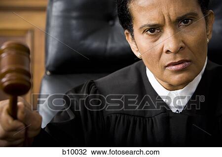 Portrait of a female judge holding a gavel and looking serious View Large Photo Image Stock Image - Portrait of a female judge holding a gavel and looking serious. Fotosearch