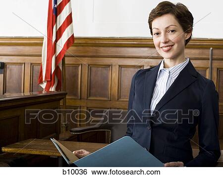 Stock Photograph - Portrait of a female lawyer standing in a courtroom and smiling. Fotosearch