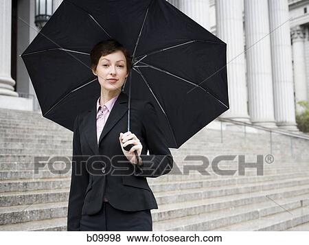 Portrait of a female lawyer standing on the steps of a courthouse and holding an umbrella View Large Photo Image Stock Photo - Portrait of a female lawyer standing on the steps of a courthouse and holding an umbrella. Fotosearch
