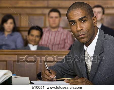 Stock Image - Portrait of a male lawyer sitting in a courtroom. Fotosearch