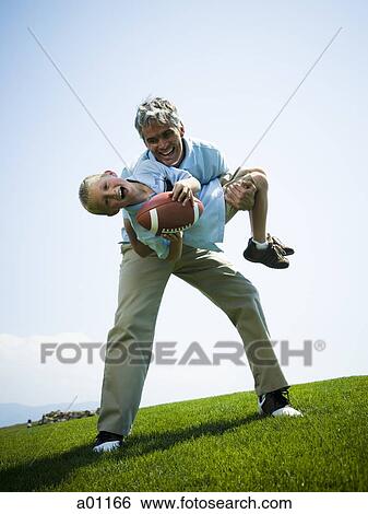 Portrait of a man carrying his son View Large Photo Image Stock Photograph - Portrait of a man carrying his son. Fotosearch