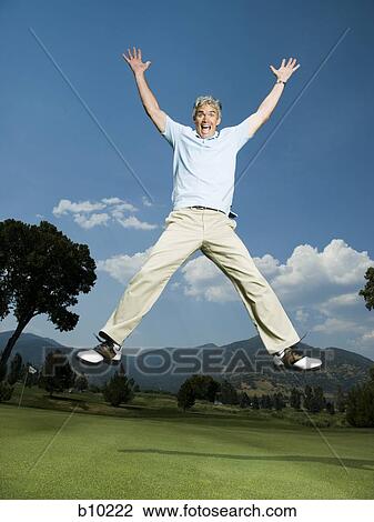 Portrait of a man jumping with his arms raised View Large Photo Image Stock Image - Portrait of a man jumping with his arms raised. Fotosearch
