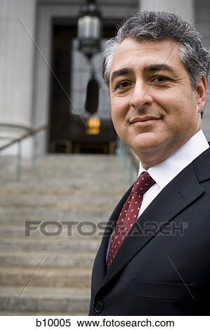 Stock Photography - Portrait of a man standing on the steps of a courthouse and smiling. Fotosearch
