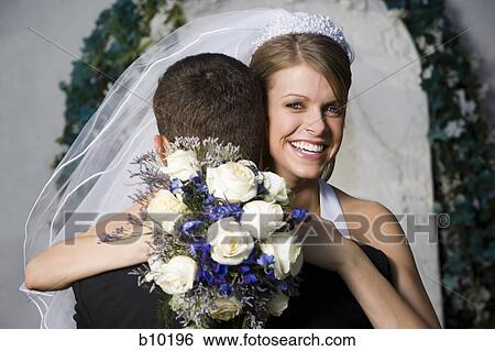 Stock Photograph - Portrait of a newlywed couple embracing. Fotosearch