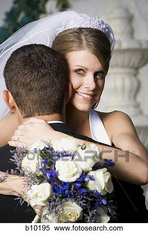 Portrait of a newlywed couple embracing View Large Photo Image Stock Photography - Portrait of a newlywed couple embracing. Fotosearch