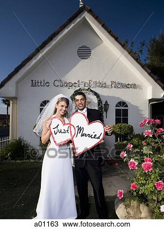Portrait of a newlywed couple smiling together in front of a chapel View Large Photo Image Stock Image - Portrait of a newlywed couple smiling together in front of a chapel. Fotosearch