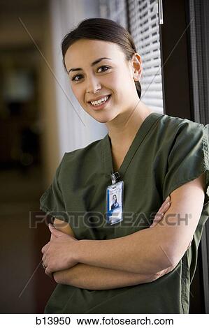 Stock Image - Portrait of a nurse with arms crossed smiling. Fotosearch