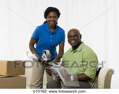 Portrait of a senior couple smiling and packing up a lamp View Large Photo Image Stock Image - Portrait of a senior couple smiling and packing up a lamp. Fotosearch