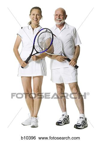 Stock Photograph - Portrait of a senior couple standing with tennis rackets. Fotosearch