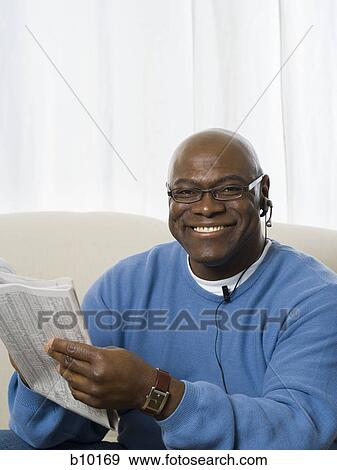 Portrait of a senior man holding a newspaper and smiling View Large Photo Image Stock Photo - Portrait of a senior man holding a newspaper and smiling. Fotosearch