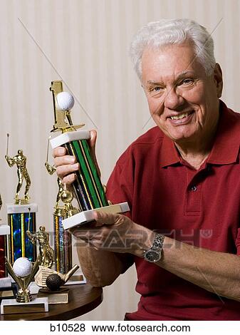 Portrait of a senior man holding a trophy View Large Photo Image Stock Photo - Portrait of a senior man holding a trophy. Fotosearch