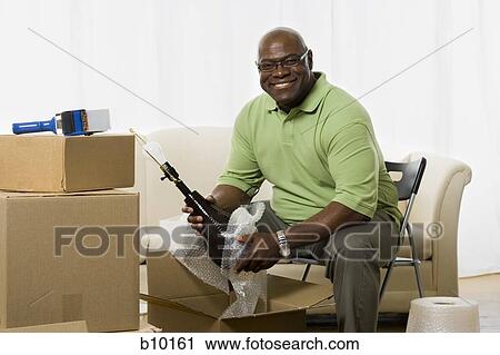 Portrait of a senior man packing up a lamp View Large Photo Image Stock Image - Portrait of a senior man packing up a lamp. Fotosearch