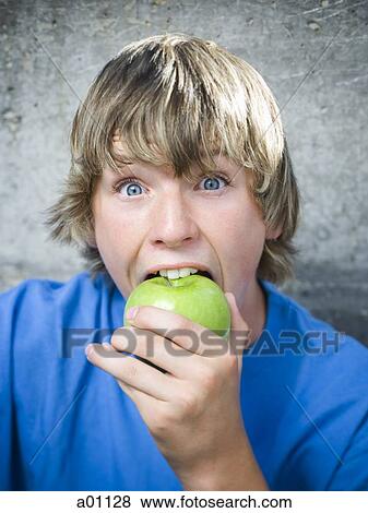Portrait of a teenage boy eating an apple View Large Photo Image Stock Photo - Portrait of a teenage boy eating an apple. Fotosearch