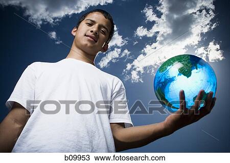 Portrait of a teenage boy holding a globe View Large Photo Image Stock Image - Portrait of a teenage boy holding a globe. Fotosearch