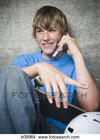 Portrait of a teenage boy using a mobile phone View Large Photo Image Picture - Portrait of a teenage boy using a mobile phone. Fotosearch