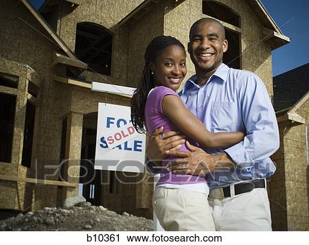 Portrait of a young couple embracing each other in front of a house and smiling View Large Photo Image Stock Image - Portrait of a young couple embracing each other in front of a house and smiling. Fotosearch
