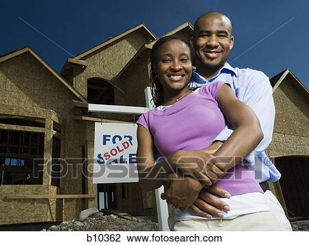 Portrait of a young couple embracing each other in front of a house and smiling View Large Photo Image Stock Image - Portrait of a young couple embracing each other in front of a house and smiling. Fotosearch