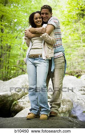 Portrait of a young couple embracing each other and smiling View Large Photo Image Stock Image - Portrait of a young couple embracing each other and smiling. Fotosearch