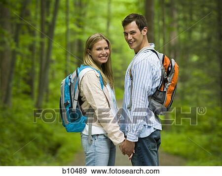 Portrait of a young couple holding hands and smiling View Large Photo Image Stock Photo - Portrait of a young couple holding hands and smiling. Fotosearch