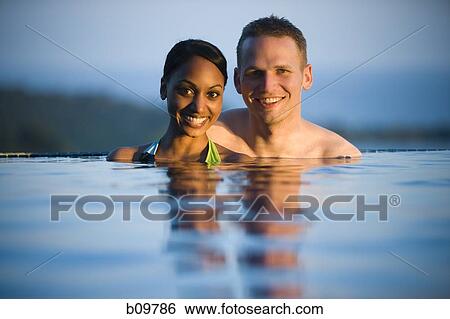 Portrait of a young couple in a swimming pool View Large Photo Image Stock Photograph - Portrait of a young couple in a swimming pool. Fotosearch