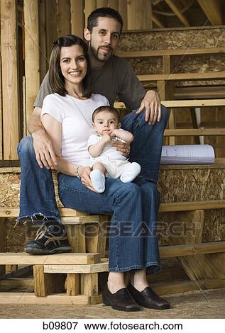 Stock Photo - Portrait of a young couple sitting with their son. Fotosearch