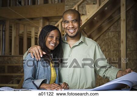Portrait of a young couple smiling in a home that is being constructed View Large Photo Image Stock Image - Portrait of a young couple smiling in a home that is being constructed. Fotosearch