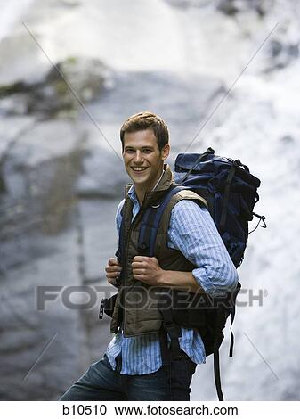 Portrait of a young man carrying a backpack View Large Photo Image Stock Image - Portrait of a young man carrying a backpack. Fotosearch