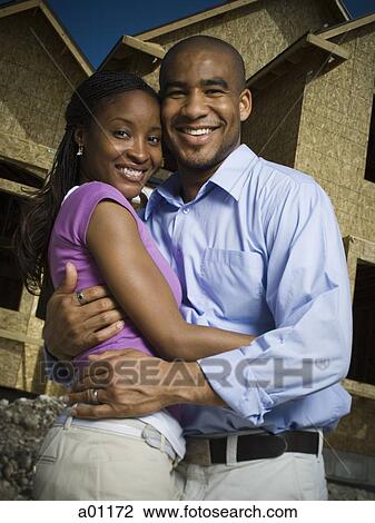 Portrait of a young man embracing a young woman in front of an unfinished home View Large Photo Image Stock Image - Portrait of a young man embracing a young woman in front of an unfinished home. Fotosearch