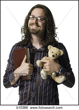 Portrait of a young man holding a book and a teddy bear View Large Photo Image Stock Photograph - Portrait of a young man holding a book and a teddy bear. Fotosearch