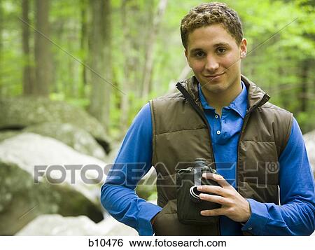 Portrait of a young man holding a bottle View Large Photo Image Stock Photograph - Portrait of a young man holding a bottle. Fotosearch