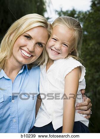 Portrait of a young woman and her daughter smiling View Large Photo Image Stock Photo - Portrait of a young woman and her daughter smiling. Fotosearch