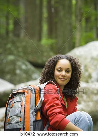 Stock Image - Portrait of a young woman carrying a bag and smiling. Fotosearch