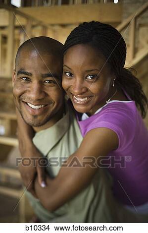 Portrait of a young woman embracing a young man from behind View Large Photo Image Picture - Portrait of a young woman embracing a young man from behind. Fotosearch