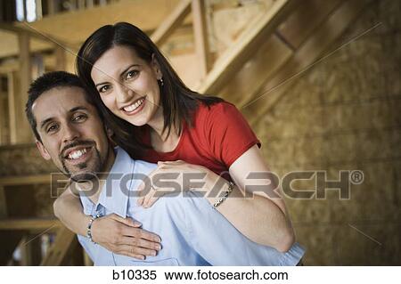 Stock Photography - Portrait of a young woman embracing a young man from behind. Fotosearch