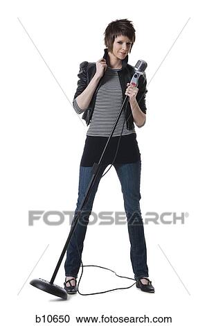 Portrait of a young woman holding a microphone and standing View Large Photo Image Stock Image - Portrait of a young woman holding a microphone and standing. Fotosearch
