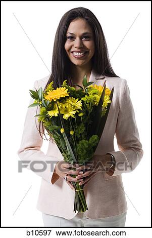 Portrait of a young woman holding a bouquet of flowers and smiling View Large Photo Image Stock Photo - Portrait of a young woman holding a bouquet of flowers and smiling. Fotosearch