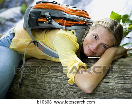 Portrait of a young woman leaning on a fallen tree View Large Photo Image Stock Image - Portrait of a young woman leaning on a fallen tree. Fotosearch