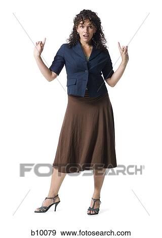 Stock Photo - Portrait of a young woman pointing upwards. Fotosearch