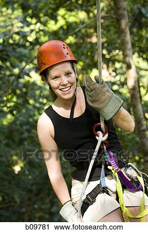 Portrait of a young woman smiling while rappelling View Large Photo Image Stock Image - Portrait of a young woman smiling while rappelling. Fotosearch