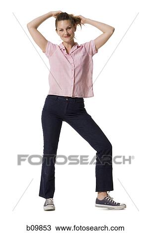 Stock Image - Portrait of a young woman smiling with her hands behind her head. Fotosearch