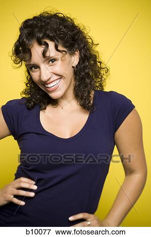 Stock Photo - Portrait of a young woman smiling with her hands on her hips. Fotosearch