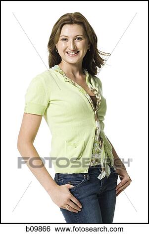 Stock Photograph - Portrait of a young woman smiling with her hands in her pockets. Fotosearch