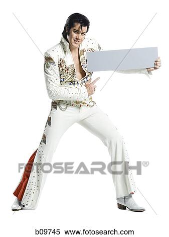 Portrait of an Elvis impersonator holding a blank sign View Large Photo Image Stock Photography - Portrait of an Elvis impersonator holding a blank sign. Fotosearch