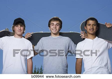 Portrait of three teenage boys holding skateboards View Large Photo Image Picture - Portrait of three teenage boys holding skateboards. Fotosearch